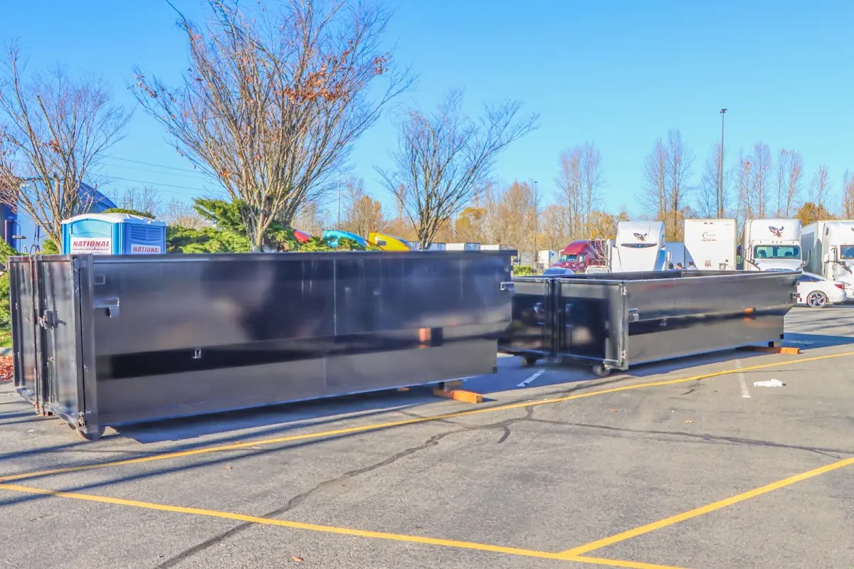 Professional dumpster rental service with roll-off container on residential driveway in Newton